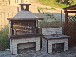 a barbecue with a sink and a brick oven at Relaxing Vacations in Siviri