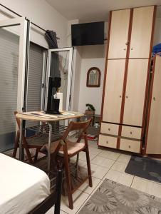 a room with a table and a bedroom with a bed at Πλάτανος Στούντιο ΙΙ Platanos studio II in Mytilene