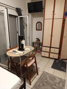 a living room with a table and a kitchen at Πλάτανος Στούντιο ΙΙ Platanos studio II in Mytilene