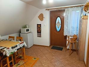 a kitchen and dining room with a table and a microwave at Zacisze pod lasem in Ruciane-Nida
