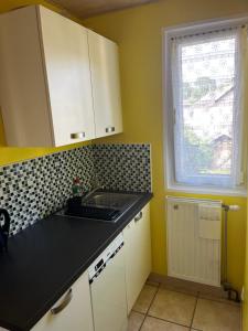 a kitchen with a black counter top and a window at Le mignon in Pontcharra