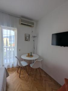 a white room with a table and chairs and a tv at Azzurro in Igalo