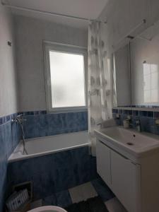 a bathroom with a tub and a sink and a window at Azzurro in Igalo +7 photos