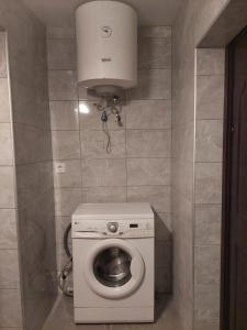a small bathroom with a washing machine and a toilet at Lind Guest House in Haapsalu