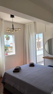 a bedroom with a bed and a large window at Relax Beach Apartment in Larnaca