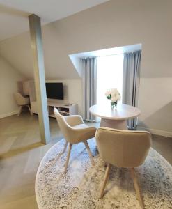 a living room with a table and two chairs at Arte Güldenstubbe Residences in Kuressaare
