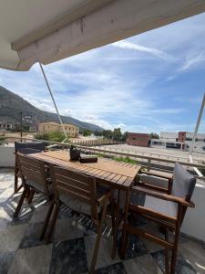 a wooden table and chairs on a roof at Elenas Apartments in Plataria