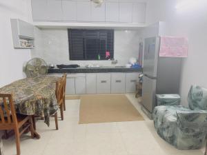 a kitchen with a table and a refrigerator at Kakon Madbor in Sekerkalsi