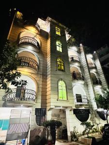 a tall white building with windows and balconies at Kakon Madbor in Sekerkalsi