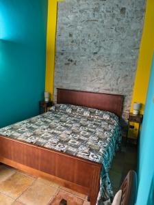 a bed in a room with a stone wall at Avalon in Pietrelcina