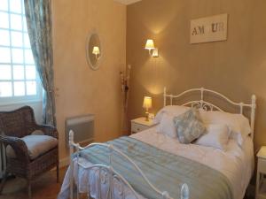 Saint-AlvèreにあるLe Montaigneのベッドルーム1室(ベッド1台、椅子、窓付)