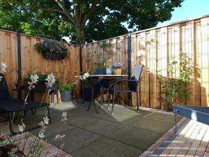 a patio with a table and chairs and a fence at Sfeervolle Studio 't kapucijntje Ossendrecht, near Antwerp in Ossendrecht