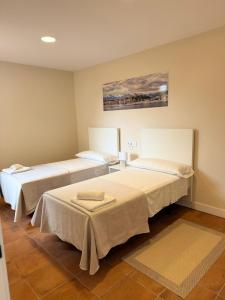 ein Zimmer mit zwei Betten und einem Gemälde an der Wand in der Unterkunft Hotel Playa de Merón in San Vicente de la Barquera + 29 Fotos