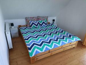 a bedroom with a bed with a colorful comforter at DOMEK SASINO in Sasino +6 photos