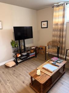 a living room with a tv and a coffee table at Eastpoint Cozy Apartment in St. John's