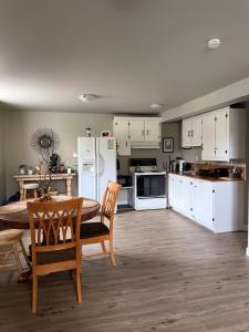 a kitchen with white cabinets and a table and chairs at Eastpoint Cozy Apartment in St. John's
