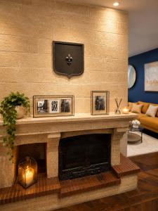 a living room with a fireplace with three pictures on it at Le Refuge de Chateau Renard in Château-Renard