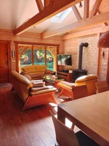 a living room with a couch and a tv at Klimatyczny domek z drewna nad morzem in Debina