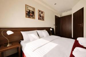 a bedroom with a large white bed and a lamp at Hotel Centrum Sosnowiec in Sosnowiec