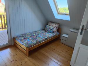 a small bed in a room with a window at DOMEK SASINO in Sasino