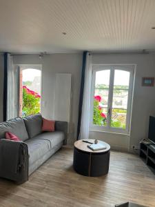a living room with a couch and a coffee table at logement de charme vue mer in Binic