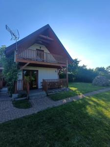 a house with a balcony and a yard at DOMEK SASINO in Sasino