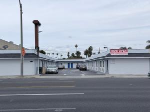 a row of buildings with cars parked in a parking lot at Coronado Motel in Long Beach
