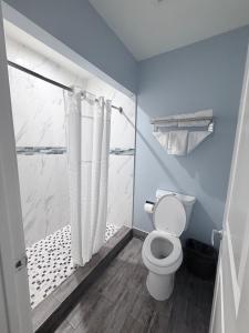 a bathroom with a shower and a toilet in it at Coronado Motel in Long Beach