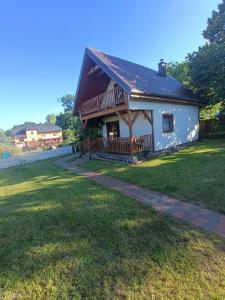 a house with a porch and a grass yard at DOMEK SASINO in Sasino