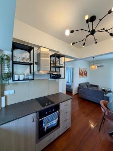 a kitchen and living room with a stove and a couch at Relax Beach Apartment in Larnaca