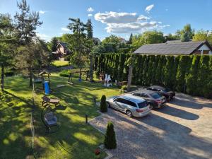 two cars parked in a parking lot in a yard at Apartment Pod Modrzewiem in Powidz