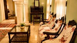 a living room with two couches and a table at Pachewar Garh - A Heritage Fort in Pachhewar