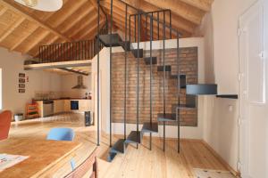 a steel staircase in a loft with a brick wall at Manas Slowliving - Santiago in Santiago do Cacém