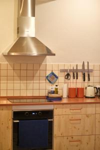a kitchen with a stove and a hood at Manas Slowliving - Santiago in Santiago do Cacém