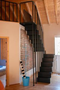 a black staircase in a room with a brick wall at Manas Slowliving - Santiago in Santiago do Cacém