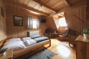a bedroom with a bed in a room with wooden walls at Willa Rohacze in Kościelisko