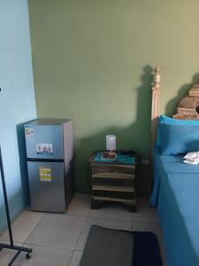 a room with a refrigerator and a nightstand next to a bed at Cheerful Private Bedroom with AC in Falmouth