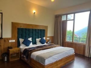 a bedroom with a large bed with a large window at MK Resort in Palchān