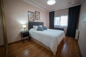 a bedroom with a large white bed and a window at Casa Alcazaba in Guadix