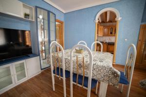 a dining room with a table and a television at Casa Alcazaba in Guadix