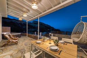 a dining room with a table and chairs on a balcony at Oniro Beach House in Archangelos
