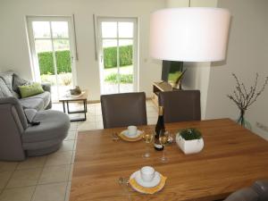 a living room with a table with a bottle of wine at Ferienwohnung Hansen in Welschbillig +7 photos