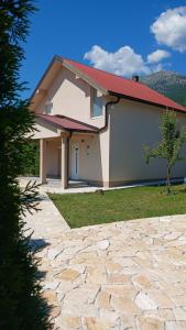 a house with a stone driveway in front of it at Vukota - Kuca za odmor in Plav
