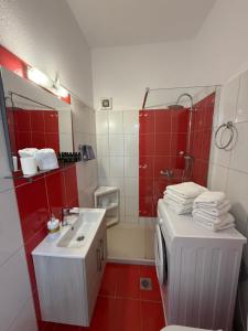 a red and white bathroom with a sink and a shower at Elenas Apartments in Plataria +61 photos