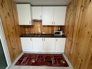 a kitchen with white cabinets and a microwave at Апартаменти Атаман in Zhovtnevoye