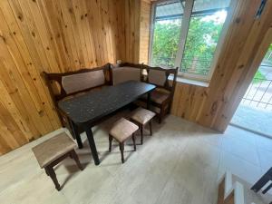 a table and chairs in a room with wooden walls at Апартаменти Атаман in Zhovtnevoye +7 photos