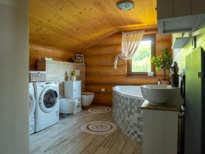 a bathroom with a tub and a washing machine at Chalet Val d'Or in Nová Baňa