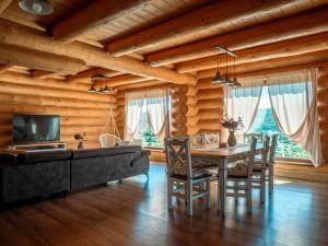 a dining room with a table and a couch at Chalet Val d'Or in Nová Baňa