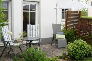 a patio with two chairs and a table and an umbrella at Ferienwohnung Hansen in Welschbillig