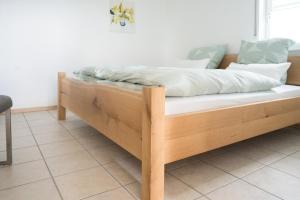 a bed with a wooden frame in a room at Ferienwohnung Hansen in Welschbillig